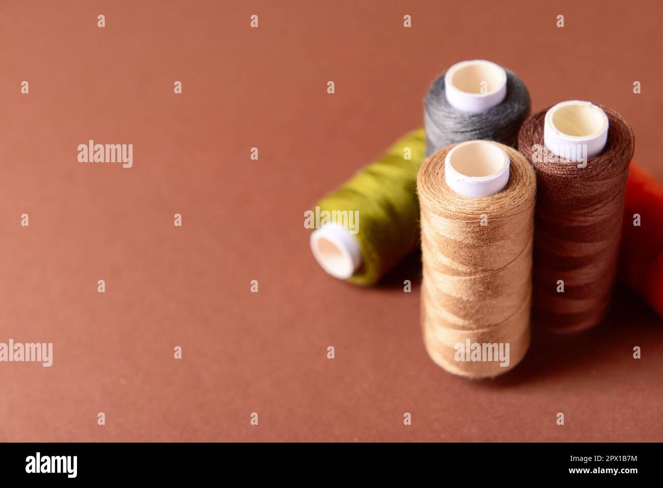 Multicolored sewing threads on color background Stock Photo