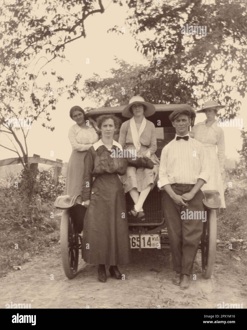 1910s MAN AND WOMAN STANDING IN FRONT OF AUTOMOBILE WITH THREE WOMEN POSED SITTING STANDING ON THE CAR ALL LOOKING AT CAMERA - o3981 HAR001 HARS BROTHERS RURAL SPOUSE EXTENDED HUSBANDS COPY SPACE FRIENDSHIP FULL-LENGTH HALF-LENGTH LADIES PERSONS AUTOMOBILE MALES SIBLINGS SISTERS TRANSPORTATION B&W PARTNER EYE CONTACT ADVENTURE AUTOS PRIDE SIBLING CONNECTION AUTOMOBILES STYLISH VEHICLES IN FRONT OF COOPERATION MID-ADULT MID-ADULT MAN MID-ADULT WOMAN POSED TOGETHERNESS WIVES YOUNG ADULT WOMAN BLACK AND WHITE CAUCASIAN ETHNICITY HAR001 HUMORLESS OLD FASHIONED Stock Photo
