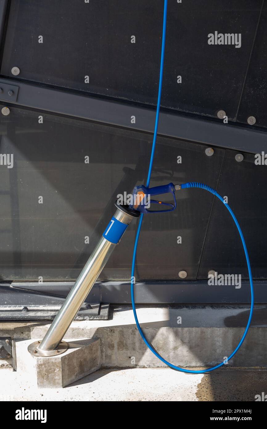 A highpressure washing gun in a holder at a selfservice car wash
