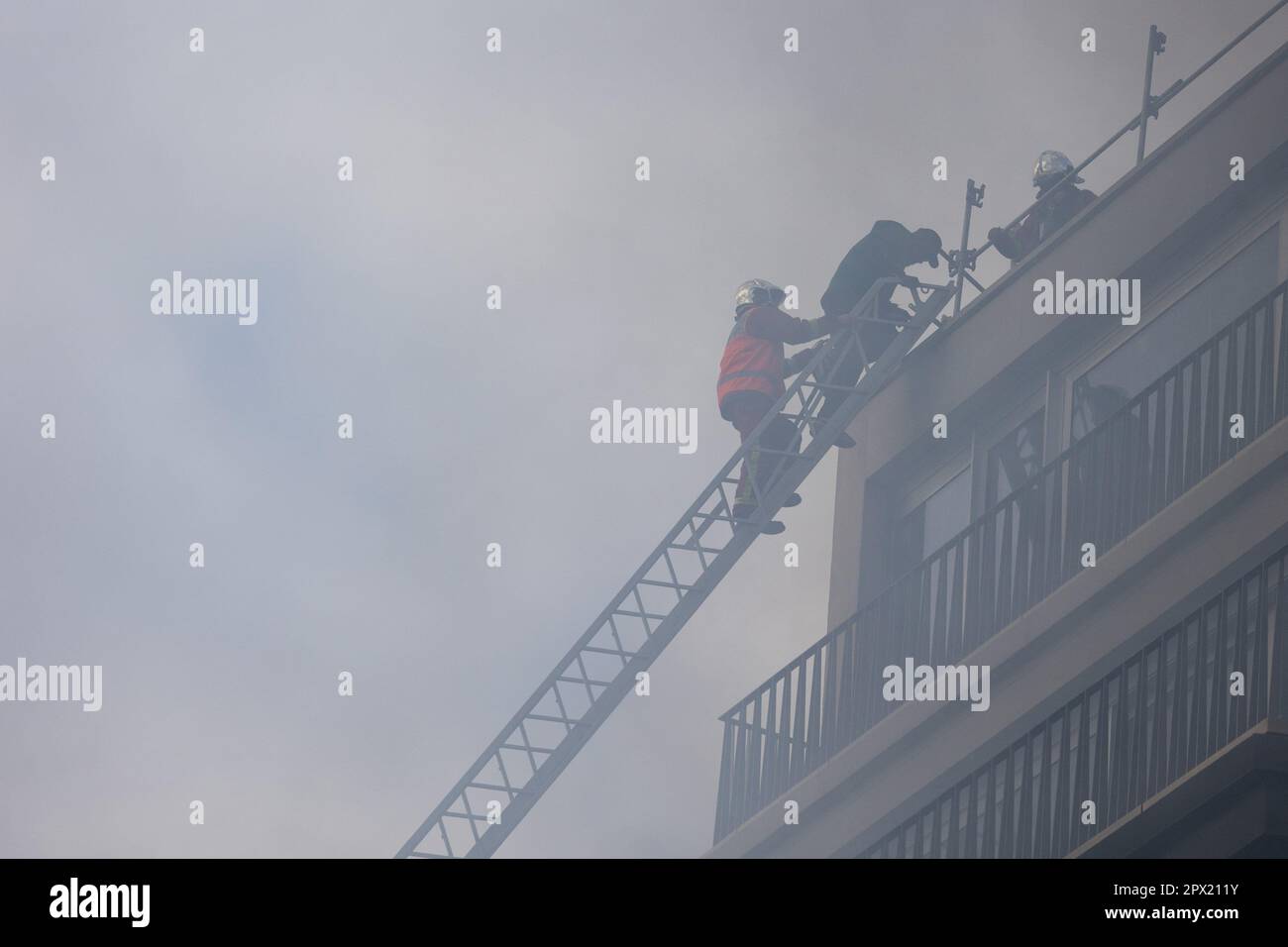 French riot police and firefighters on the big ladder extuinguish a ...