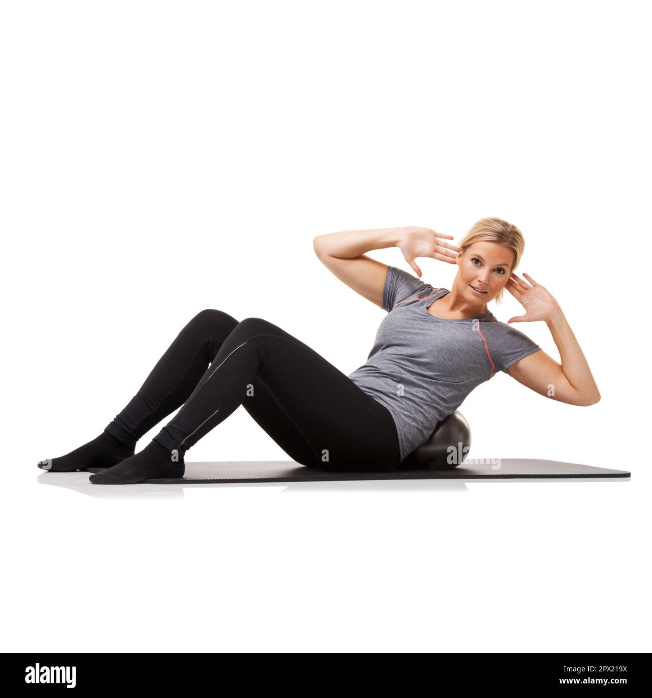 Giving her obliques workout. A young woman doing sit-ups on an exercise ...