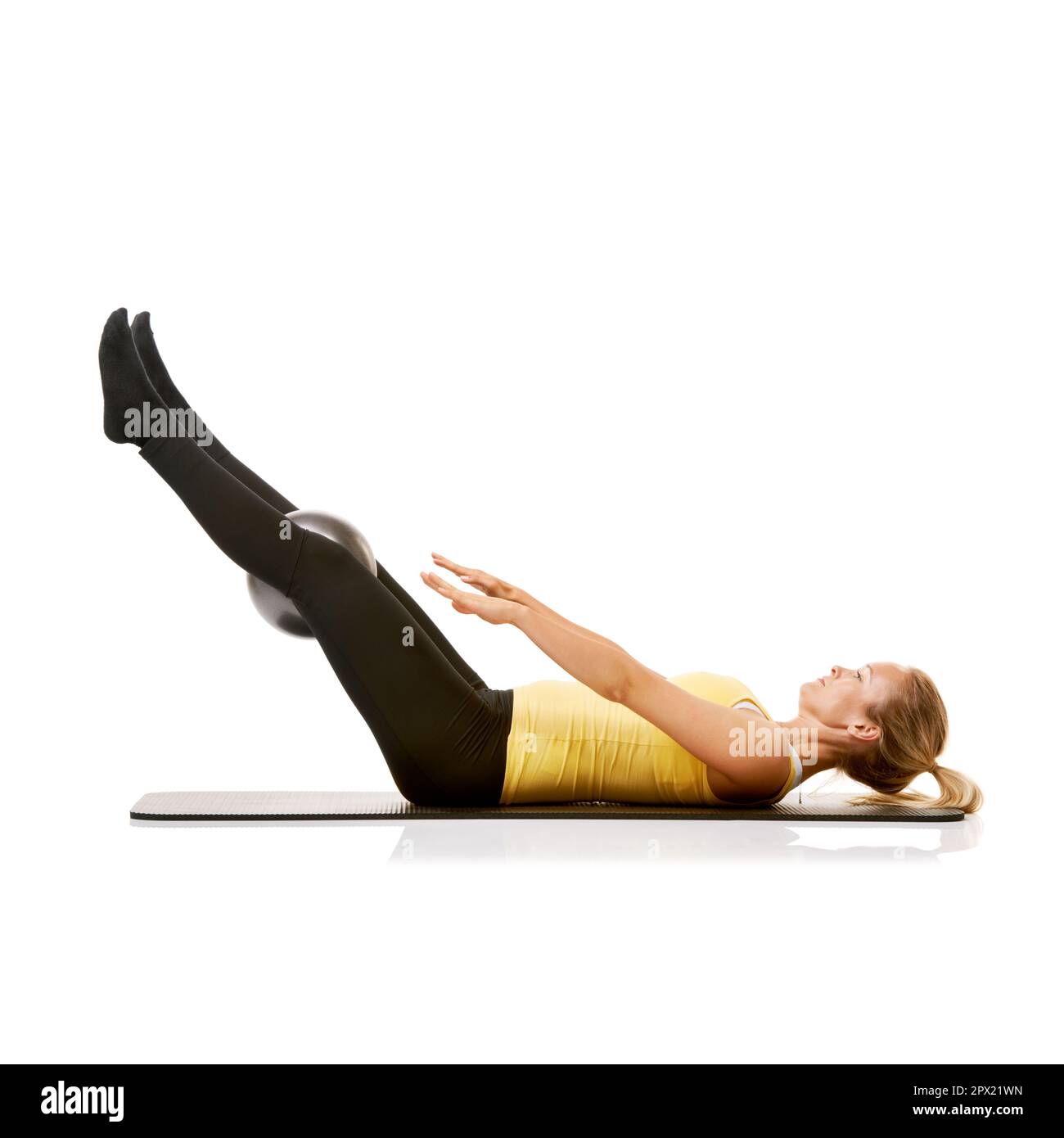 Strengthening her core with leg lifts. A young woman working out with