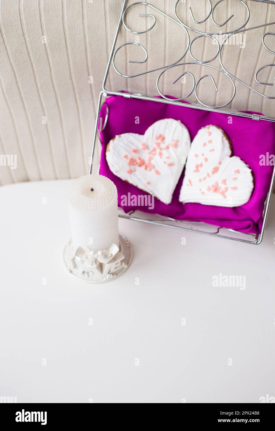 candle and biscuits in the form of heart on a pink napkin Stock Photo