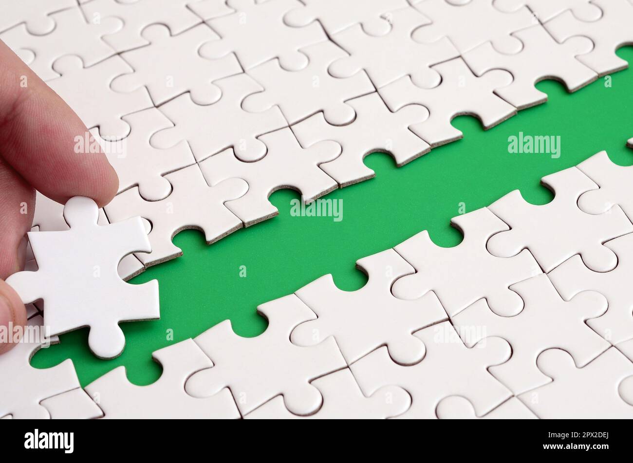 The human hand paves the way to the surface of the jigsaw puzzle The human hand paves the way to the surface of the jigsaw puzzle