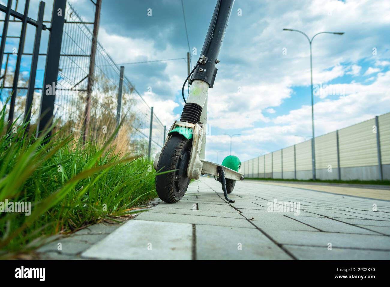 Single electric scooter stands on the pavement next to the street Stock