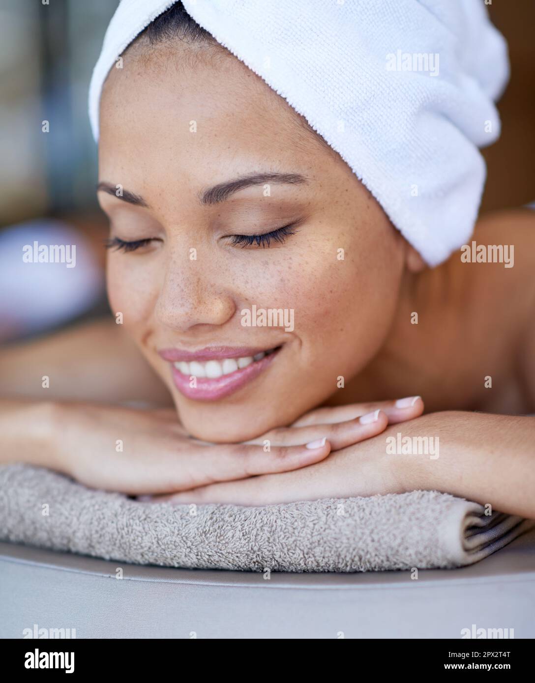 The spa makes her happy. a young woman lying on a massage table Stock
