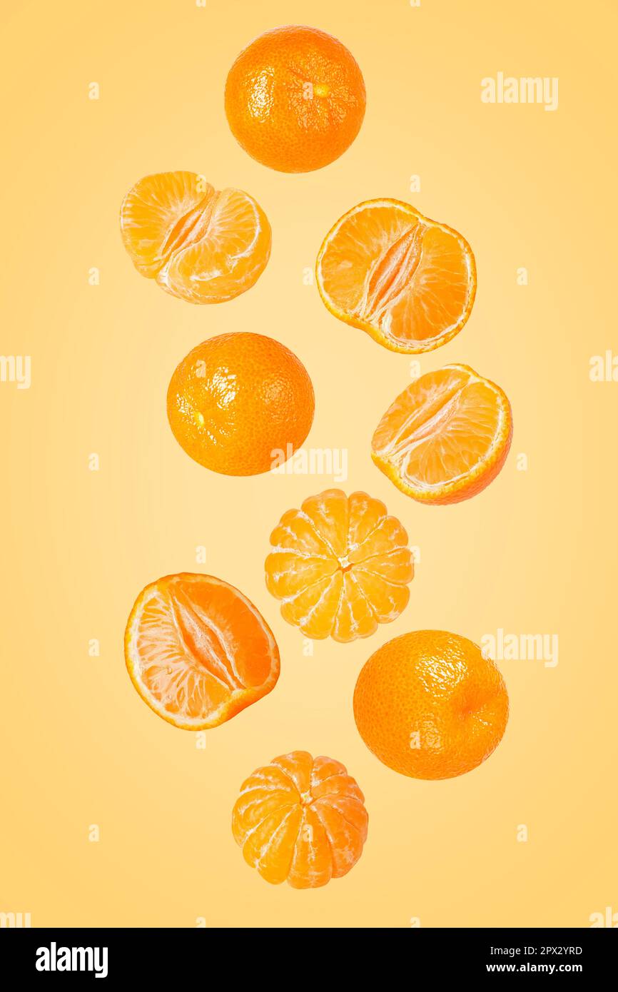 Isolated flying grapes. Nine whole and sliced mandarin fruits falling