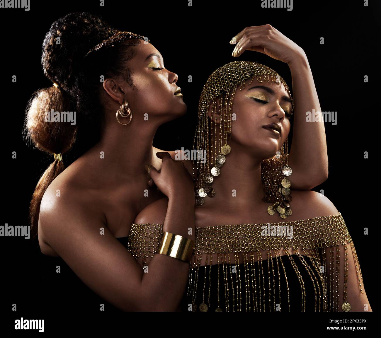 Real queens fix each others crowns. two attractive and elegantly dressed  young women posing together against a dark background Stock Photo - Alamy