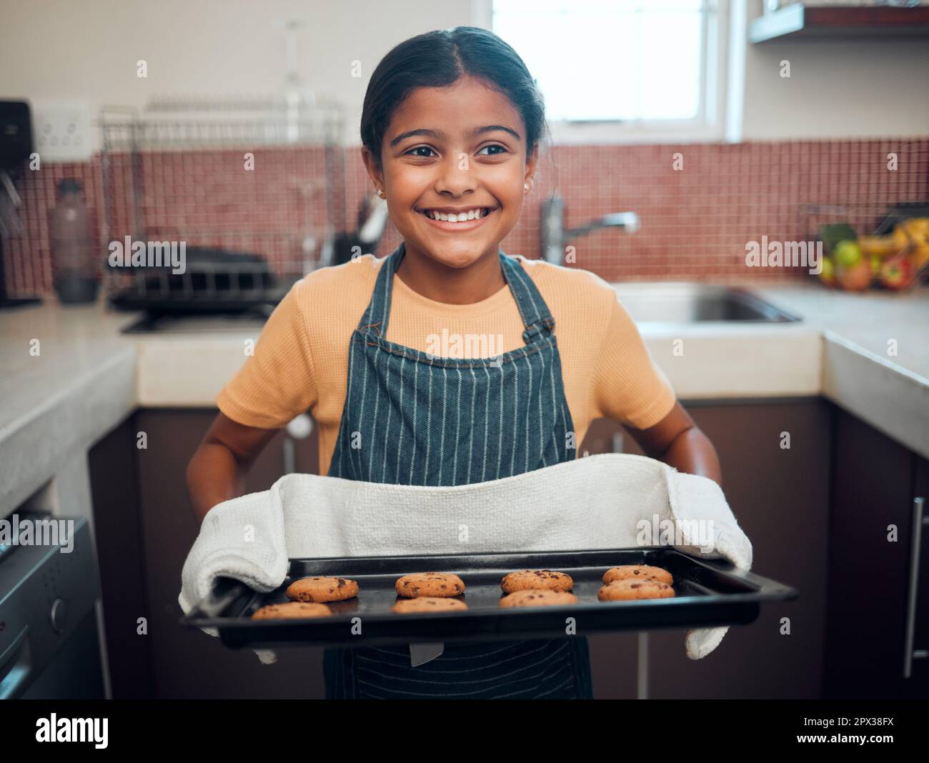 https://c8.alamy.com/comp/2PX38FX/baking-cookies-and-children-with-an-indian-girl-cooking-baked-goods-in-the-kitchen-of-her-home-alone-food-kids-and-apron-with-a-female-child-learni-2PX38FX.jpg