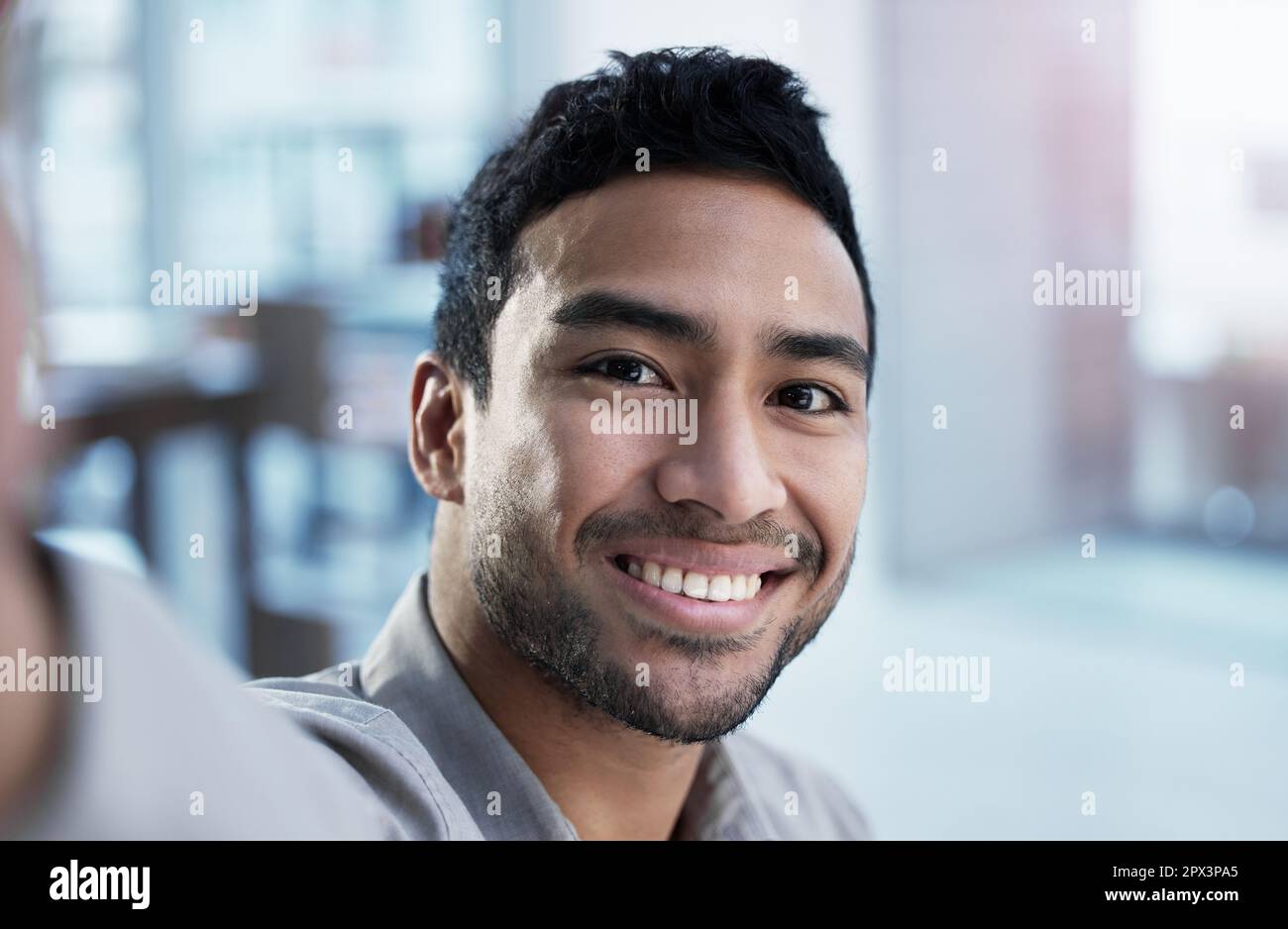 Adjusting my webcam. a handsome young customer service agent sitting alone  in the office and taking a selfie Stock Photo - Alamy
