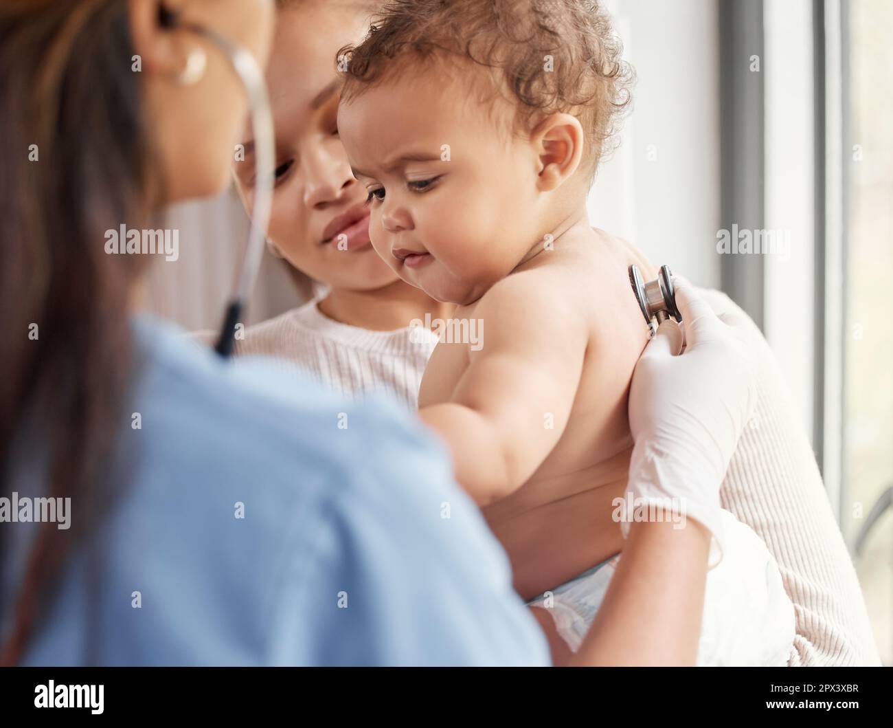 What a cutie pie. a doctor listening to a babys chest with her