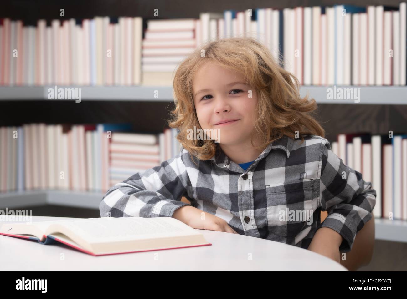 Childhood and education concept. Child reading a red book in the