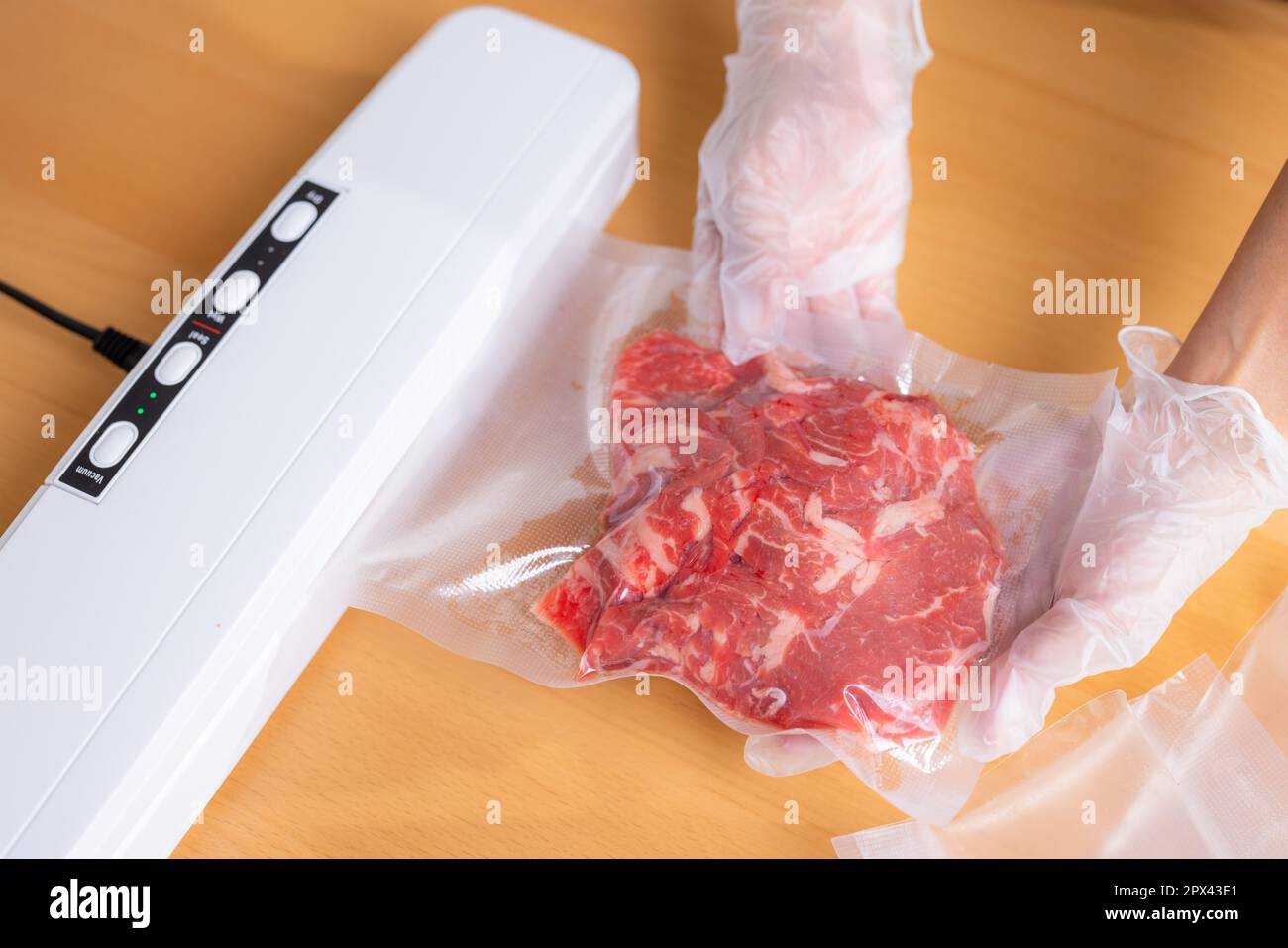 Raw beef meat sealed in plastic shrink wrap with vacuum sealer Stock Photo