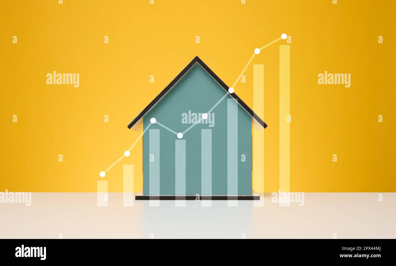 Wooden house and a graph with growing indicators. Rising property ...
