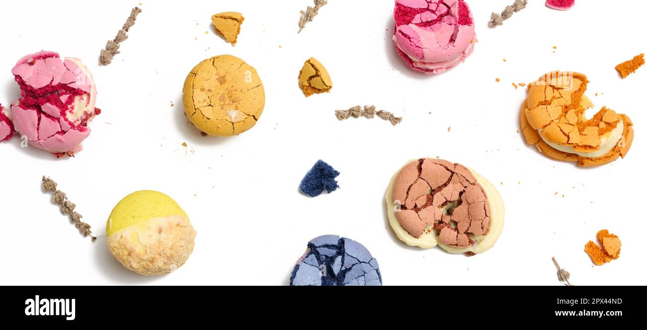 Broken round macarons with crumbs on a white background, delicious dessert, top view Stock Photo