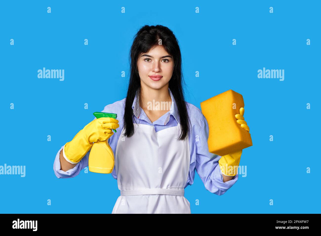 caucasian woman in yellow rubber gloves and cleaner apron with sponge ...
