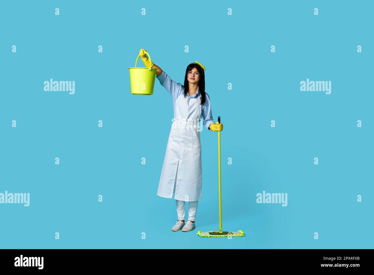 charming woman in rubber gloves and cleaner apron holding mop and ...