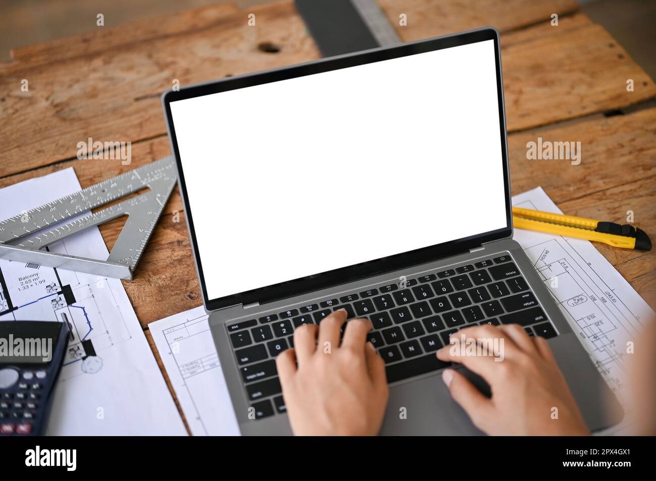 Close-up image of a professional female engineer or architect working on her building project on a laptop in the office. laptop white screen mockup Stock Photo