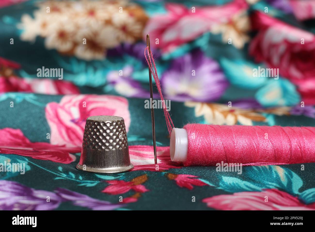 Spool of Pink Thread and Thimble on Vintage Pink Satin and Feather Fabric  Stock Photo - Alamy