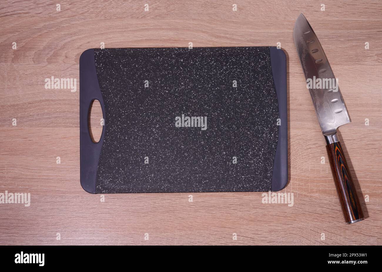 Empty plastic black board and kitchen knife on the table, top view Stock Photo