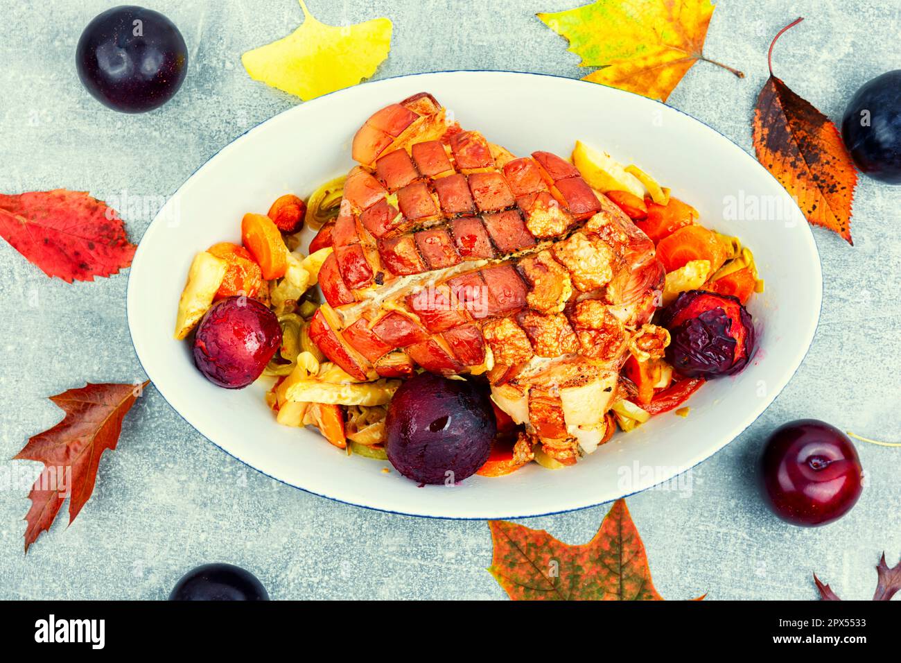 Juicy pork shoulder with skin and bacon cooked with plums Stock Photo