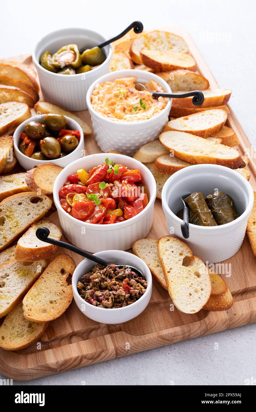 Snack board with toasted baguette and variety of dips and appetizers