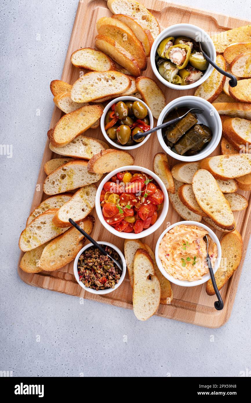 Snack board with toasted baguette and variety of dips and appetizers