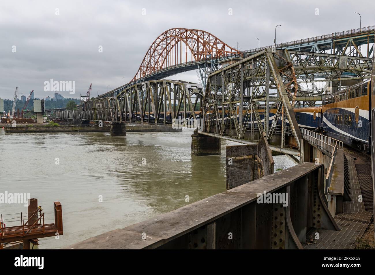 Rocky Mountaineer train crossing Pattullo arch bridge and Fraser River between New Westminster and Surrey, British Columbia, Canada. Stock Photo