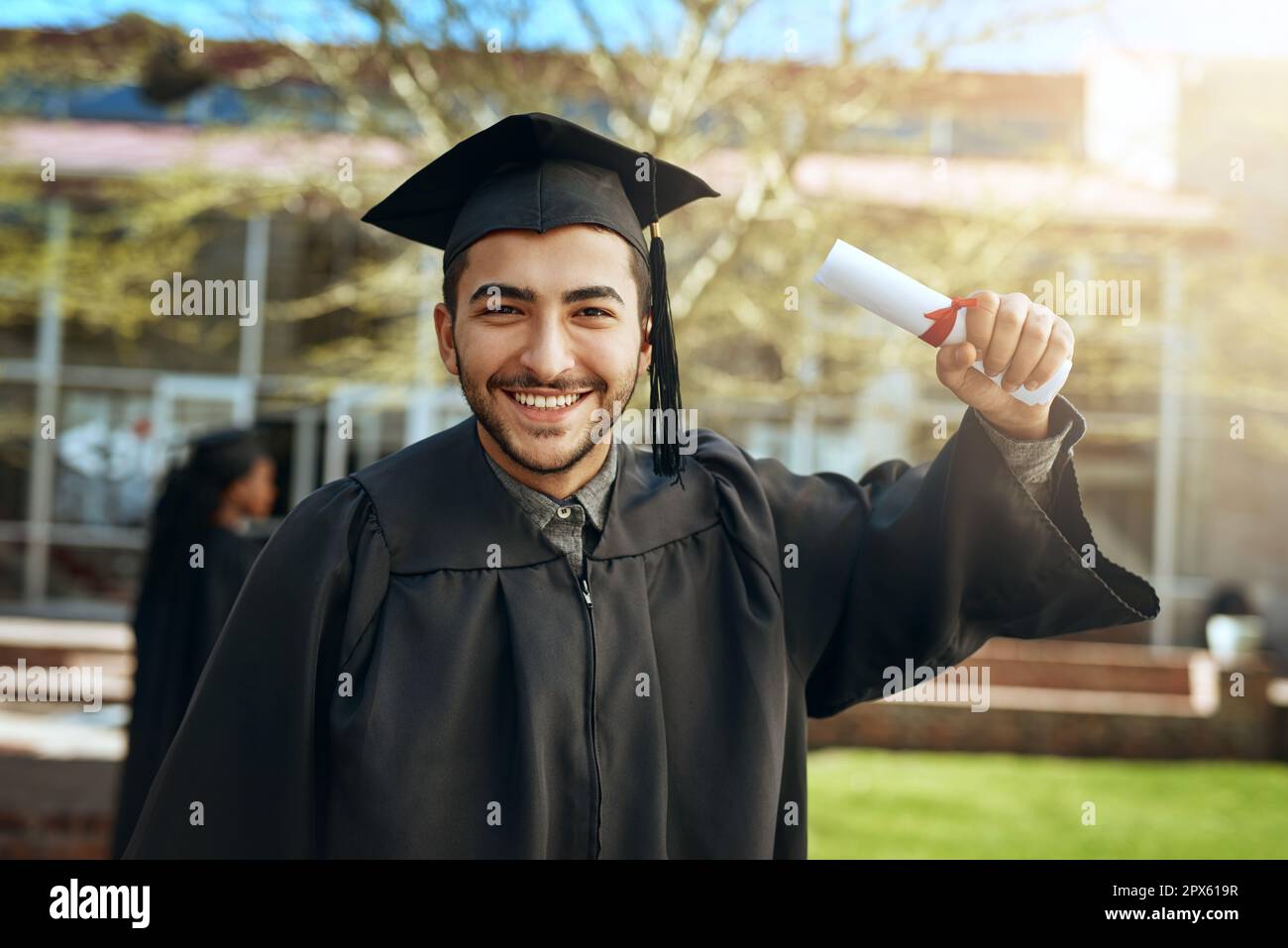 See you at the top. Portrait of a happy young man holding a diploma on ...