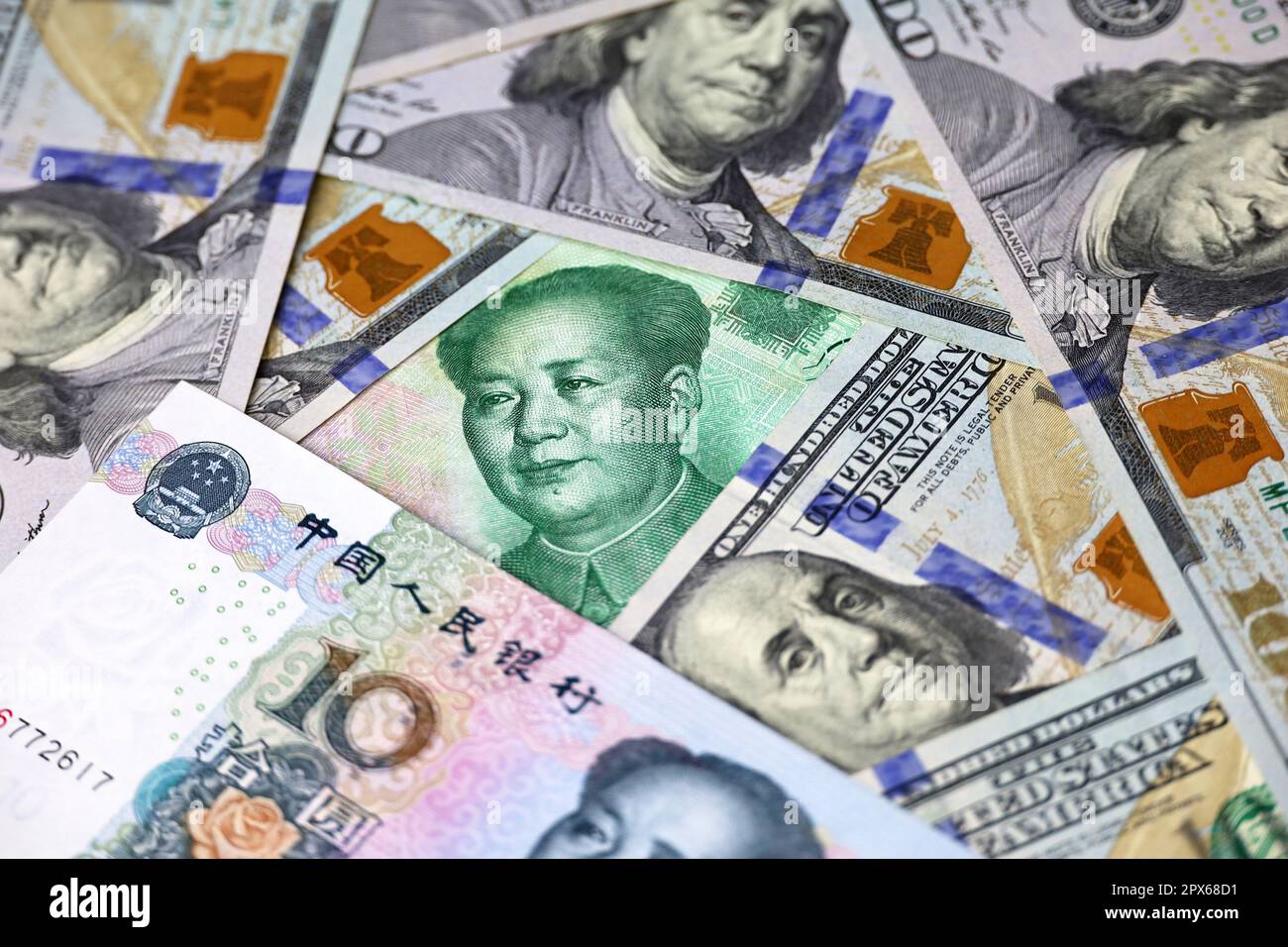Chinese yuan banknotes and US dollars. Concept of trade war between the