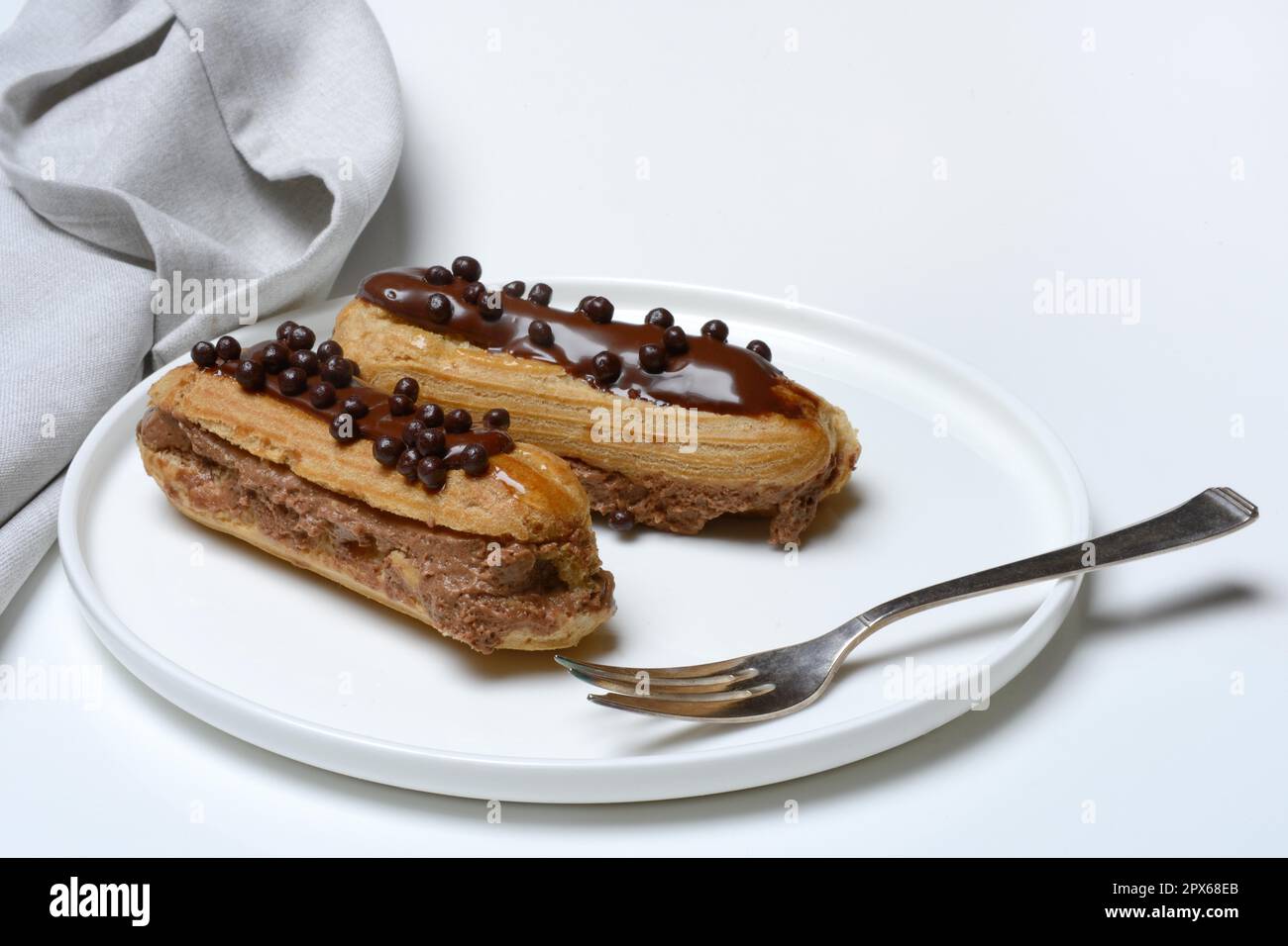 Two chocolate eclairs on a plate, eclair Stock Photo