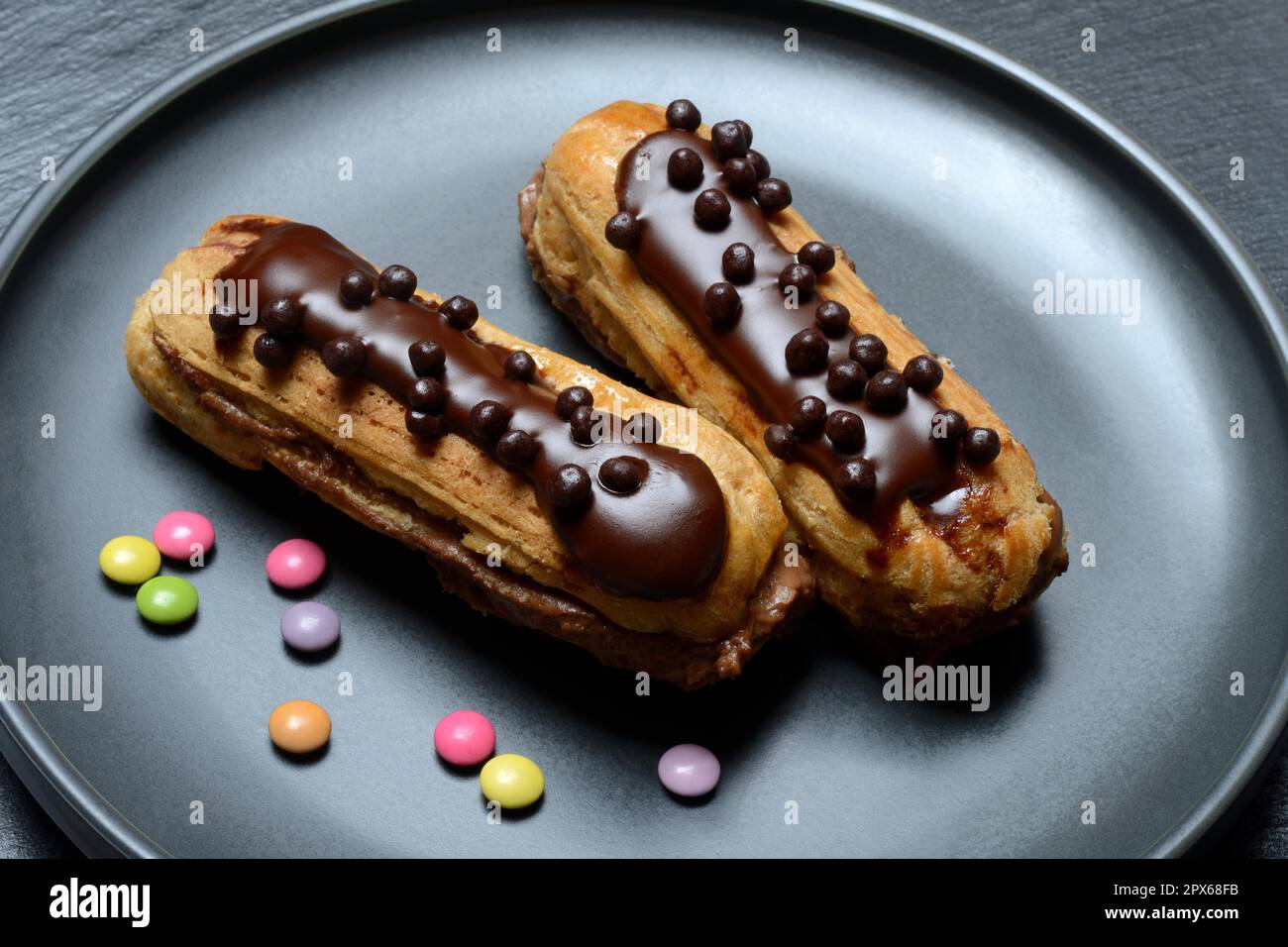 Two chocolate eclairs on a plate, eclair Stock Photo