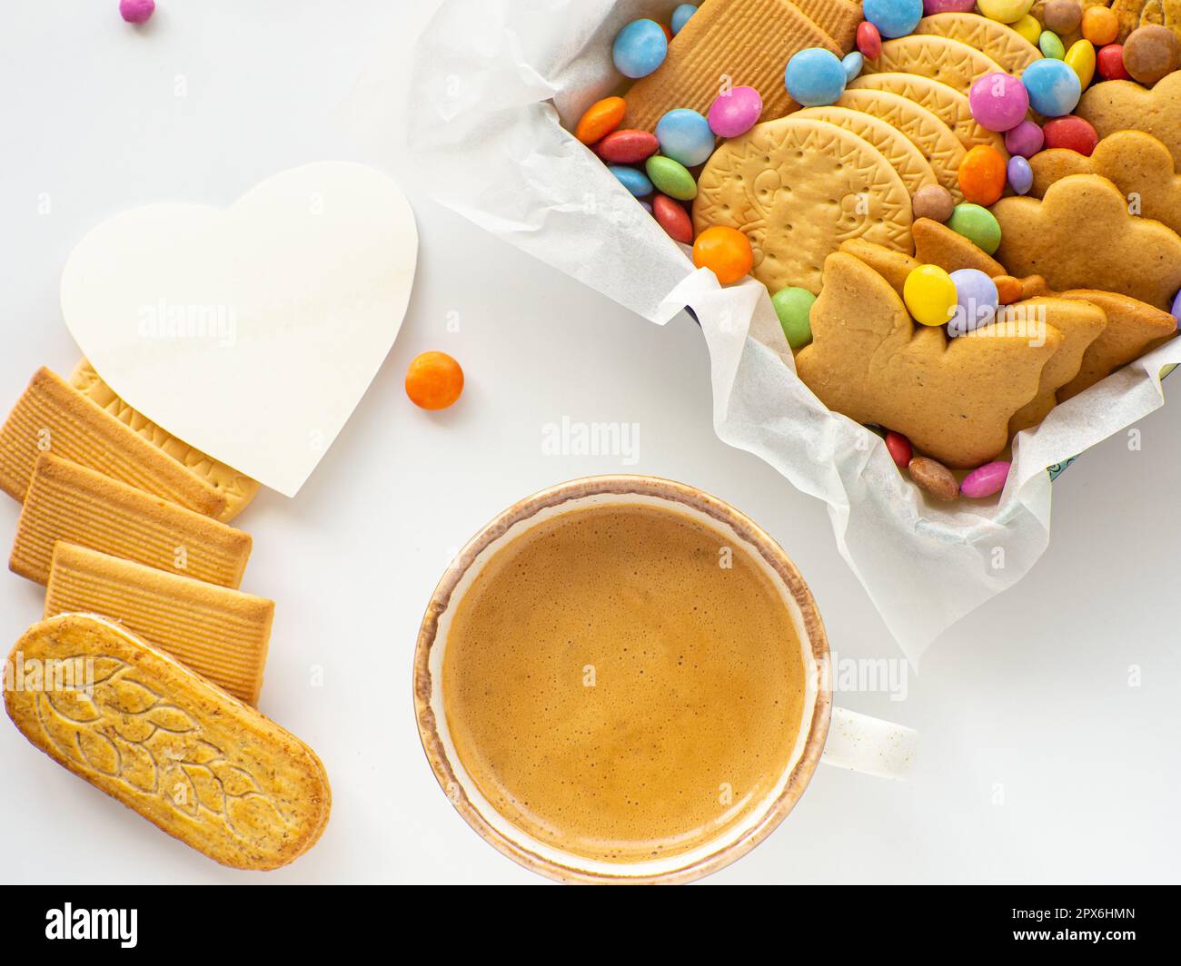 Assorted cookies and candies in basket and cup of coffee. Mothers Day