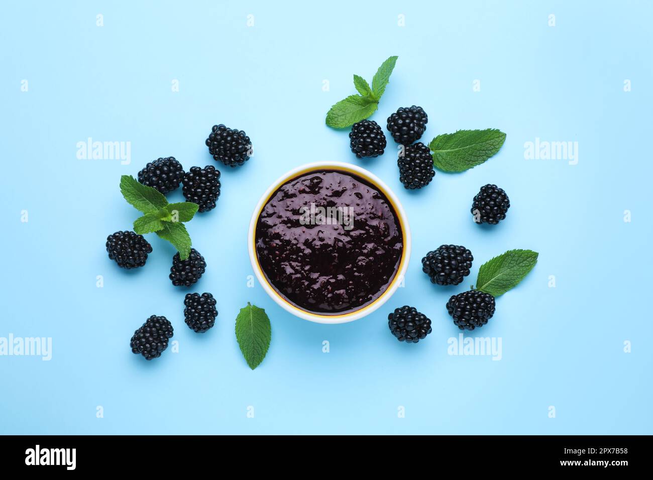 Blackberry puree in bowl and fresh berries with mint on light blue  background, flat lay Stock Photo - Alamy