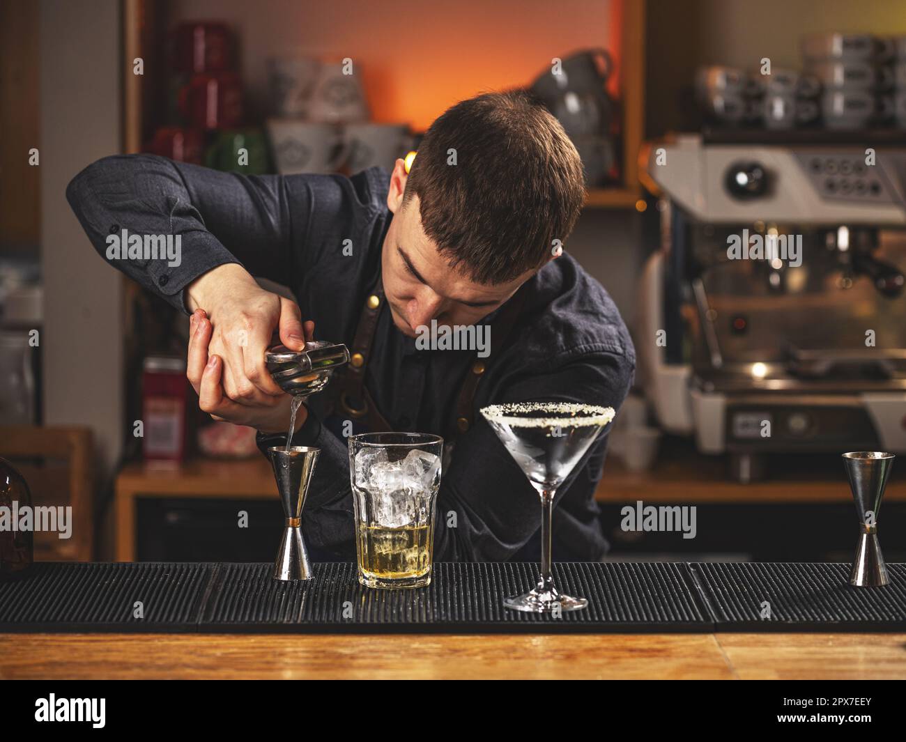 Professional bartender squeeze lime juice with an iron tool Stock Photo