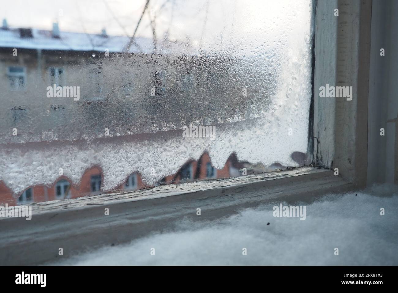 Ice, snow and frozen water crystals on glass. Window with double wooden ...