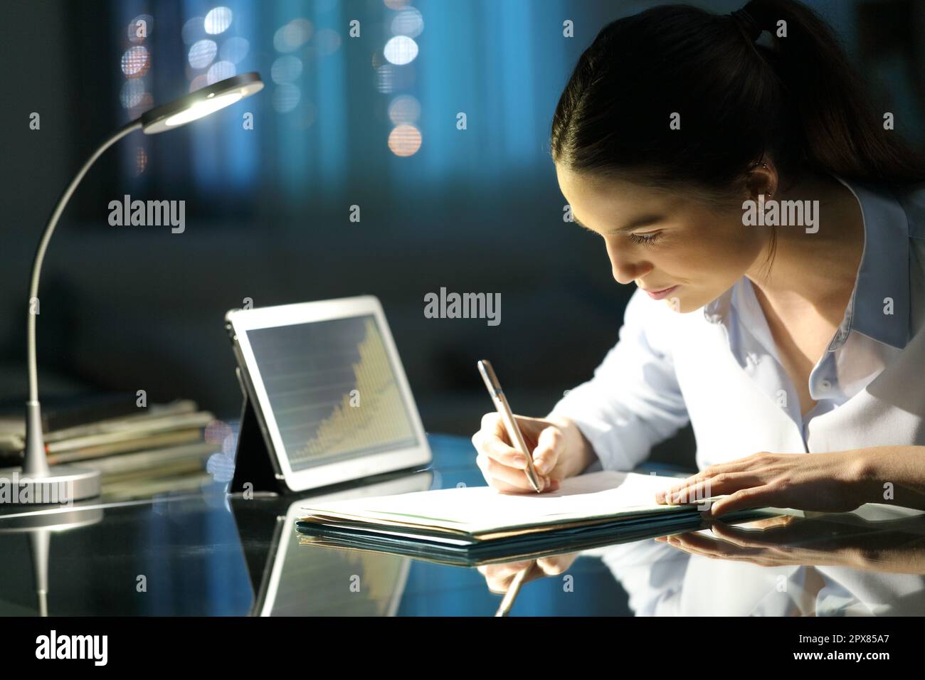 Entrepreneur working in the night taking notes on a desk Stock Photo