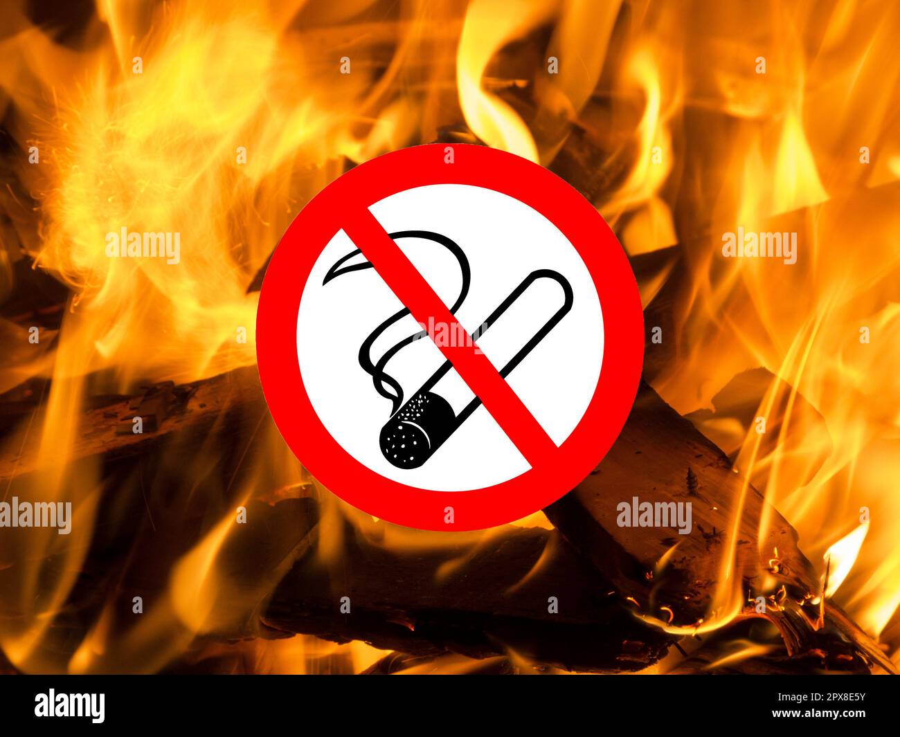 Close up of flames of flickering bonfire with inserted pictogram smoking prohibited Stock Photo