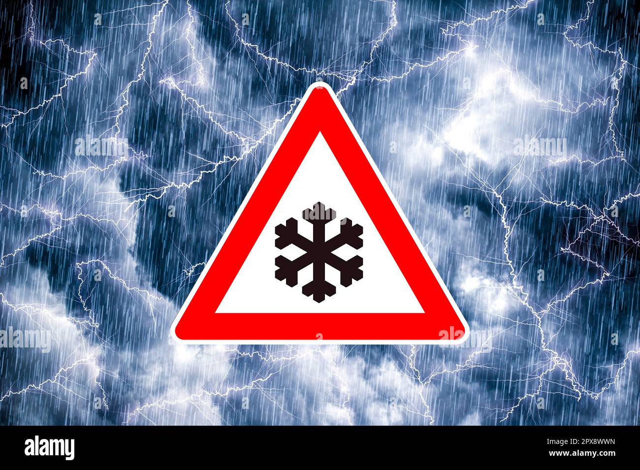 Snowfall warning sign in front of dramatic bluegray cloudy sky with