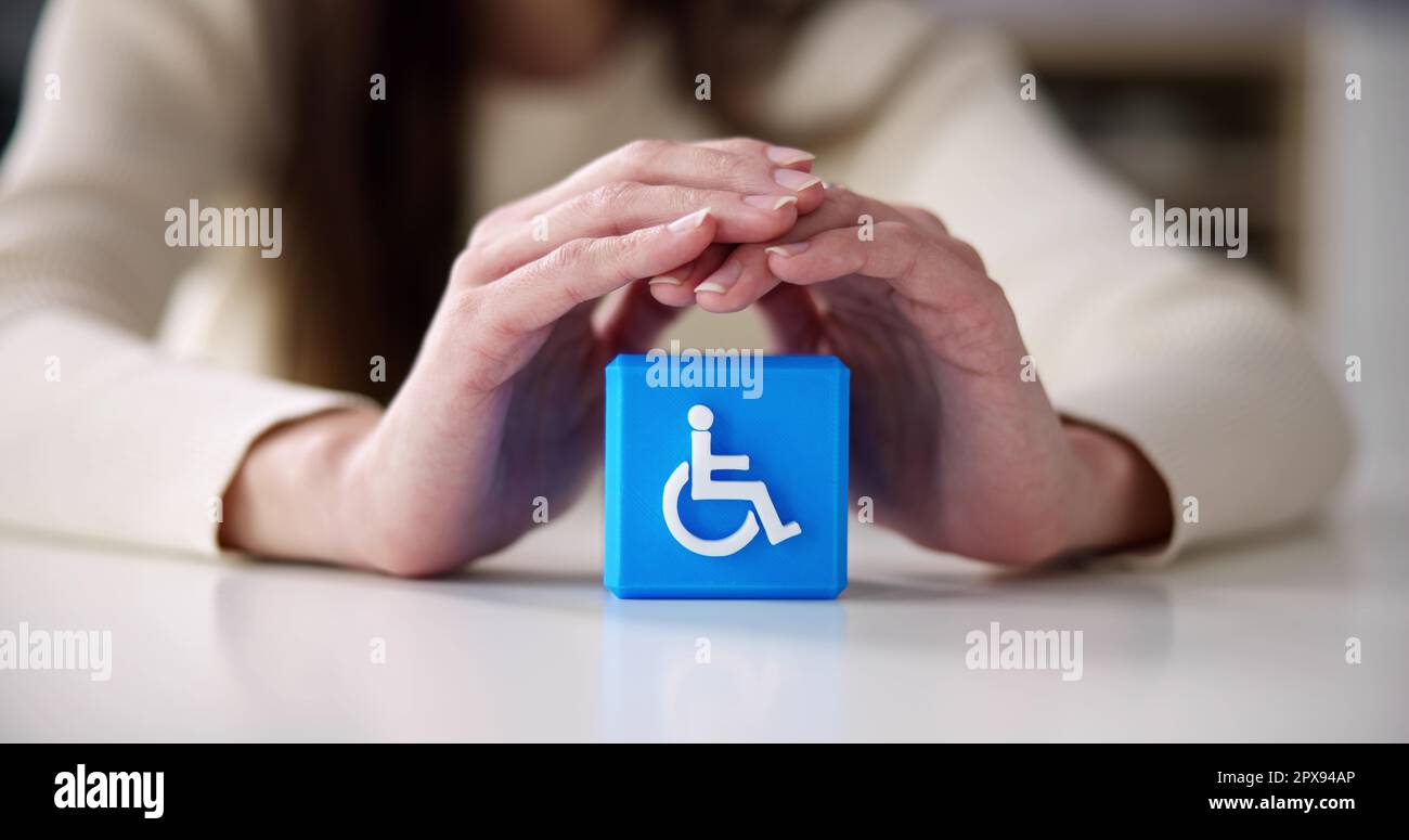 Person's Hand Protecting Blue Cubic Block With Disabled Icon Stock ...