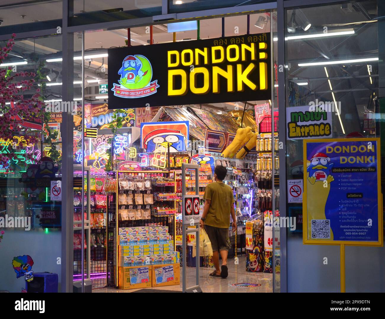 a-shopper-enters-a-shop-to-look-at-products-for-sale-in-don-don-donki-a-japanese-discount-chain-store-in-silom-area-bangkok-thailand-2PX9DTN.jpg