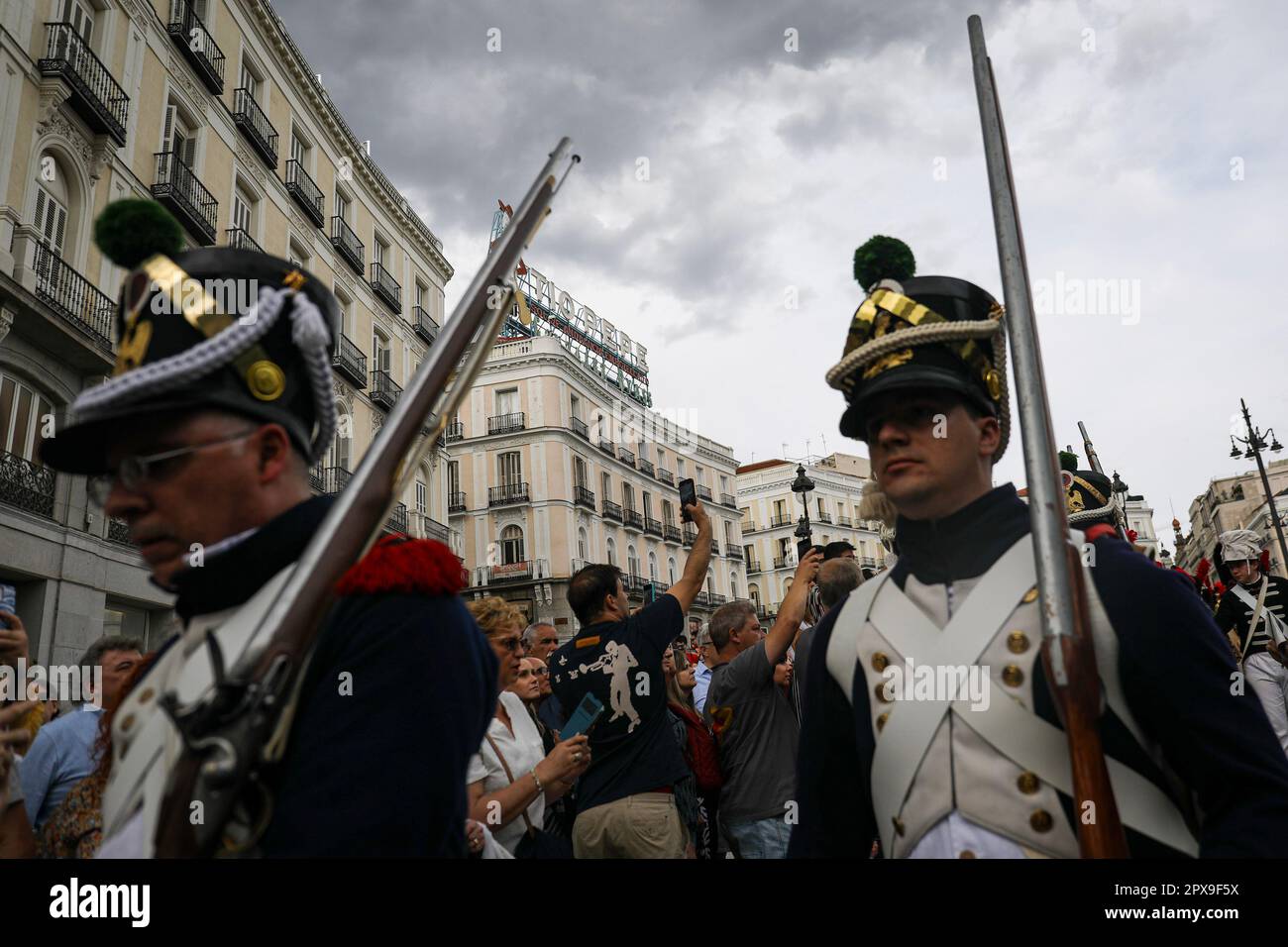 Two actors, dressed in French soldier costumes, walk through the Puerta