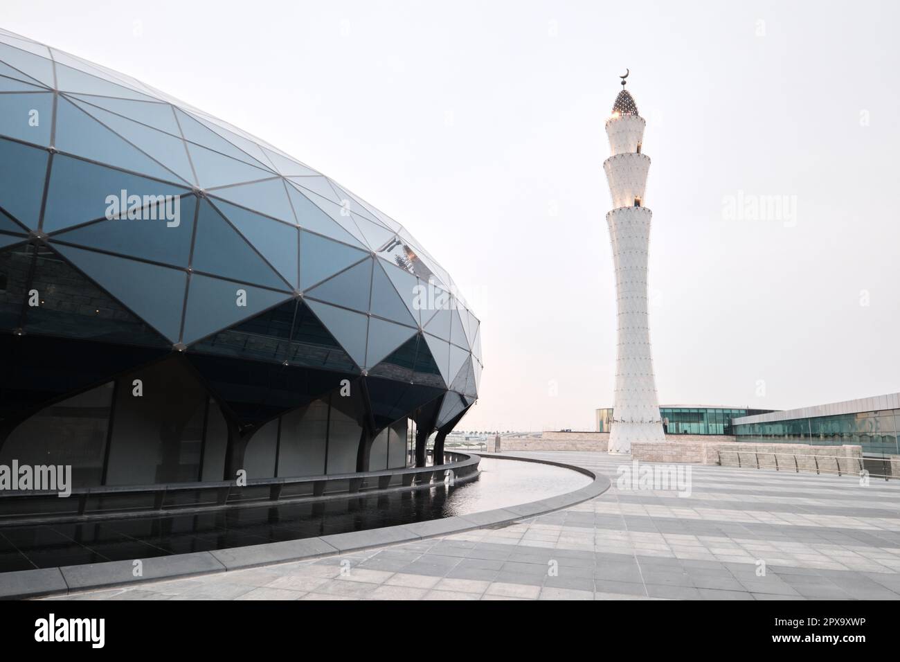 Doha, Qatar - April 2023: Hamad International Airport mosque with glass dome architecture and traditional minaret design Stock Photo