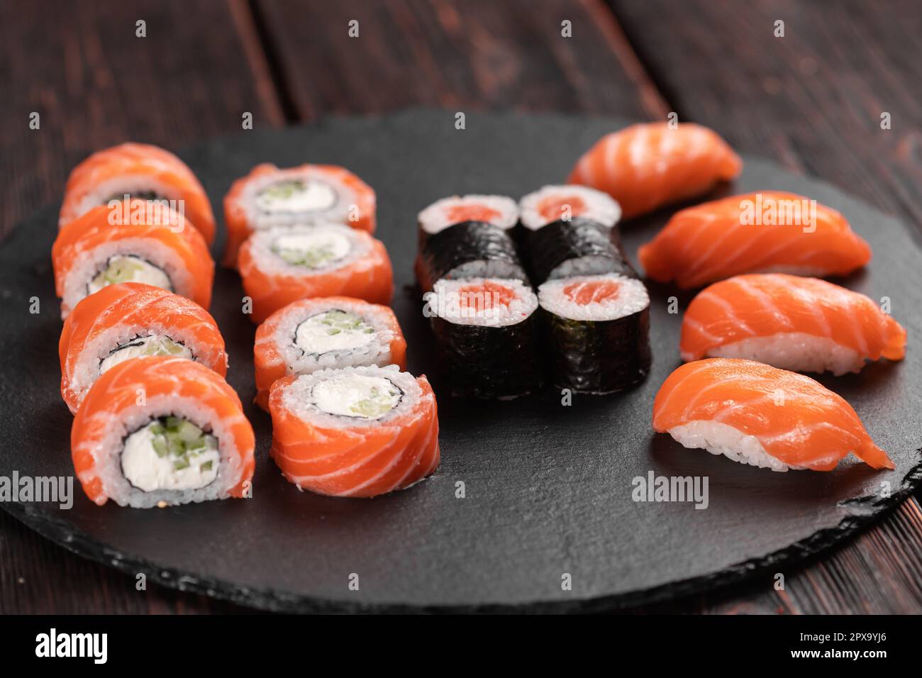 Large sushi set from top on black background. Assortment of various