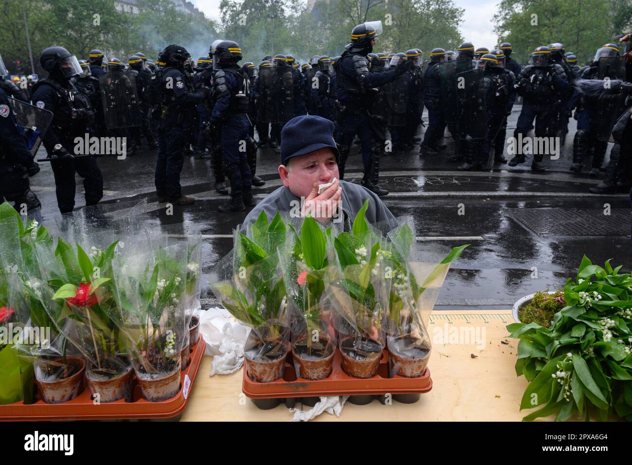 Paris, France. 1st May, 2023. A Lily of the Valley vendor protects