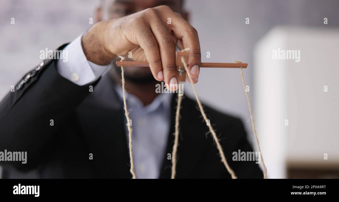 Manipulation With Hand Holding Puppet Strings Stock Photo