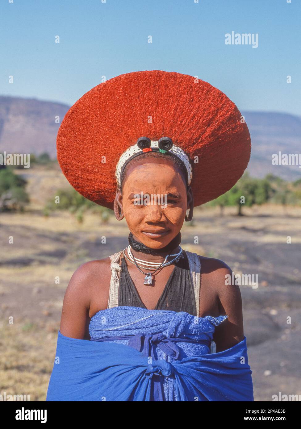 KWAZULU-NATAL, SOUTH AFRICA - MAY 2, 2023: Portrait of a beautiful Zulu woman, with her baby, in traditional dress and wearing an isicholo hat. Stock Photo