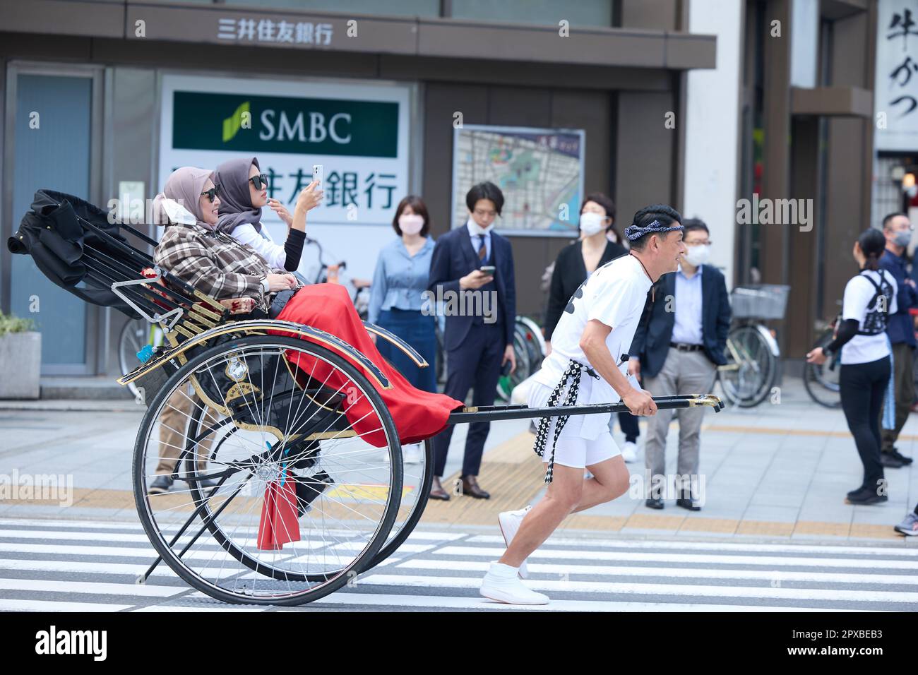 A rickshaw puller carries foreign tourists near Nakamise shopping ...