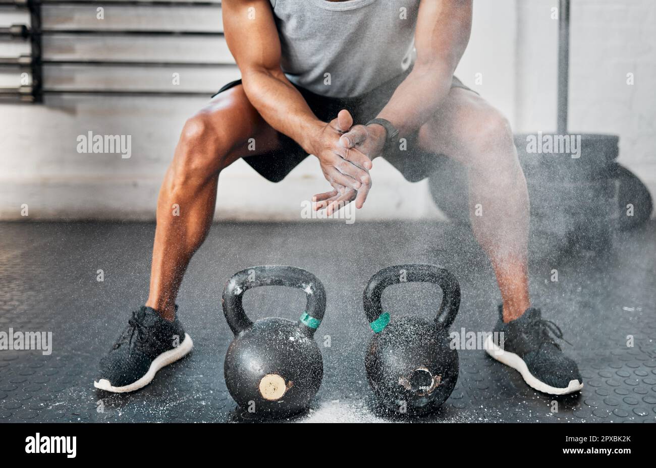 Keep those blisters from forming. a man dusting his hands with chalk before using kettlebells