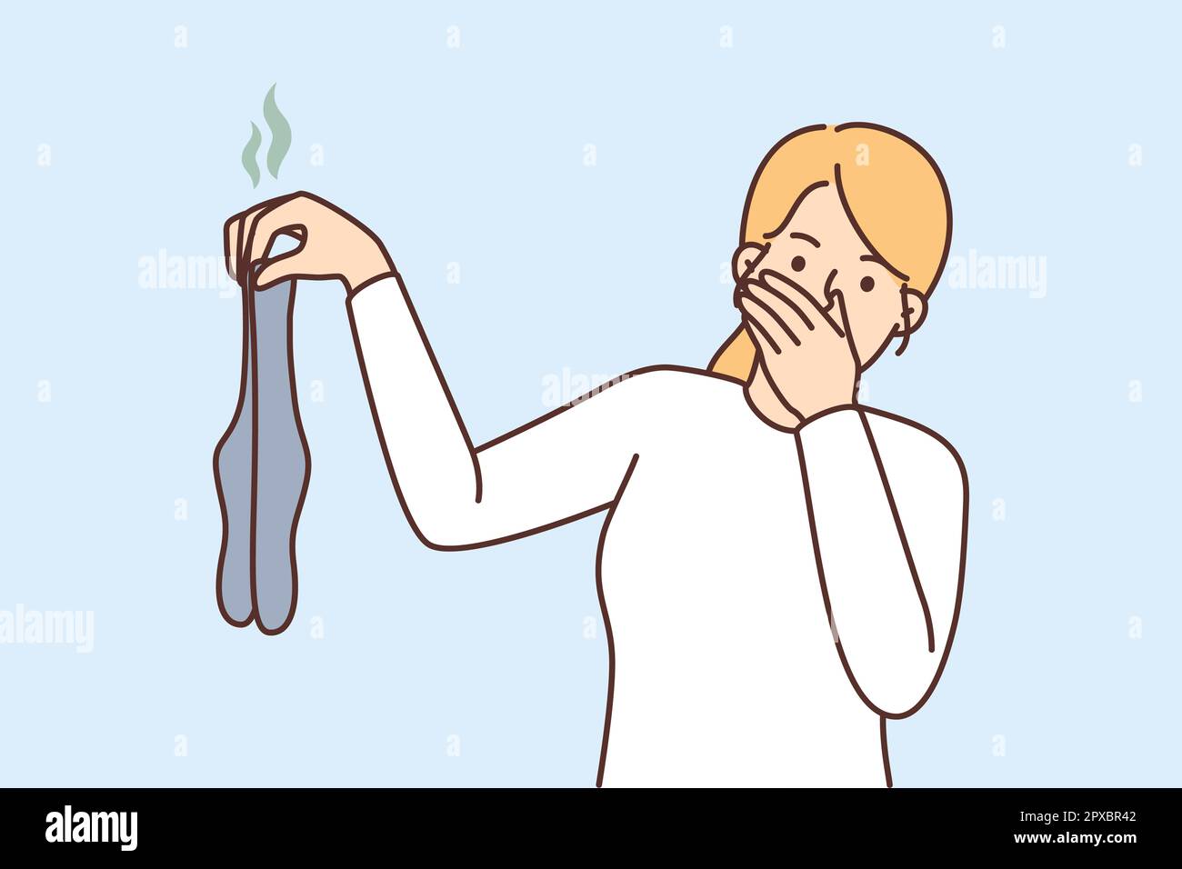 Young woman holding dirty stinky socks in hands disgusted by smell